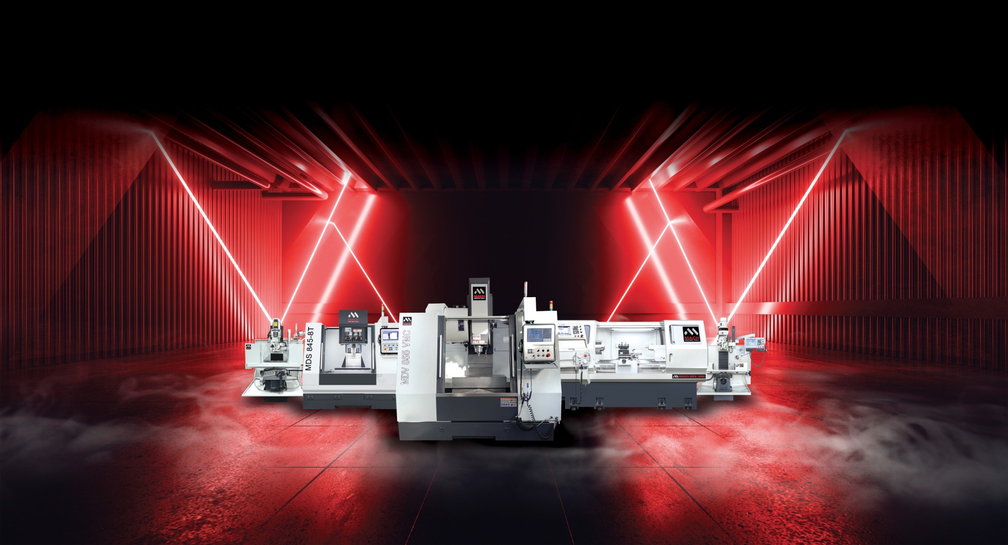 A line-up of MACH CNC machining centres and a lathe, including the MDV 1160 VMC, lit in red